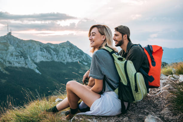 young couple of hikers enjoying the beautiful nature from high above